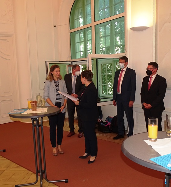 Ministerin Weidinger übergibt Urkunde an Absolventin